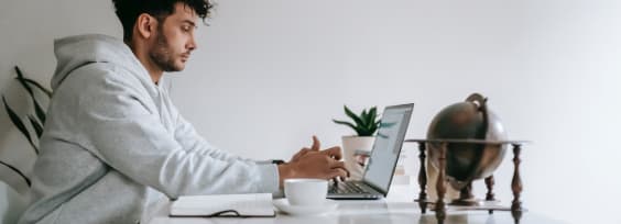 A man sitting at a laptop, browsing