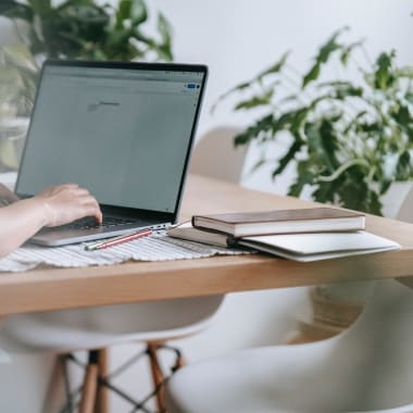 a woman sitting by a desk with a computer on it