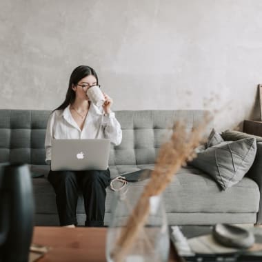 a woman sitting on a couch with a laptop