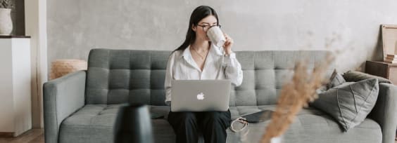 a woman sitting on a couch with a laptop