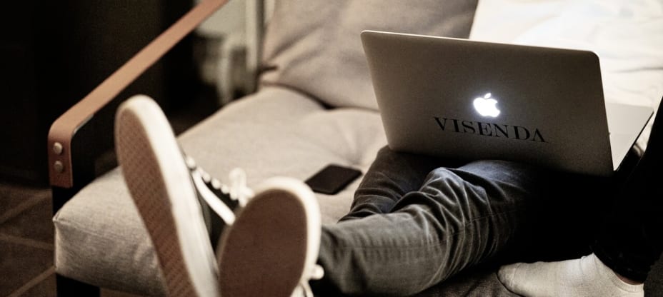 Person sitting on the coach with their Macbook