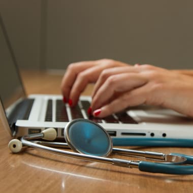 Hands on laptop with stethoscope