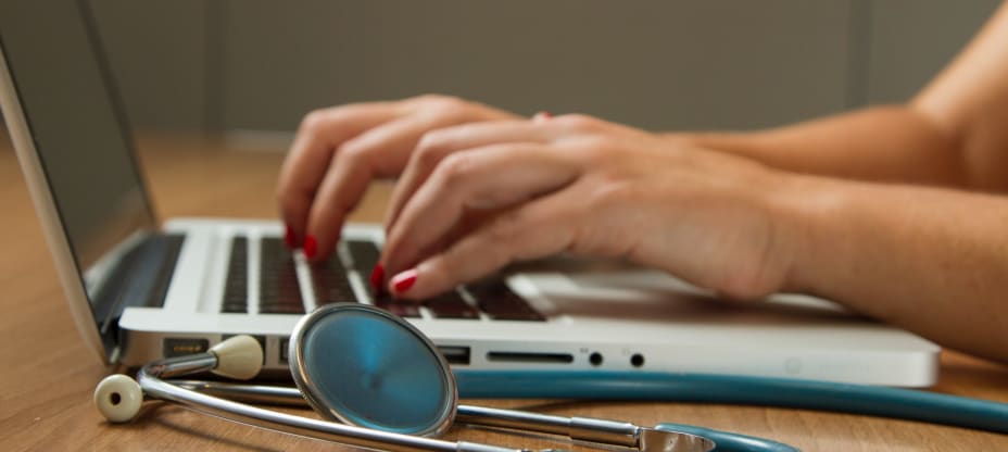 Hands on laptop with stethoscope