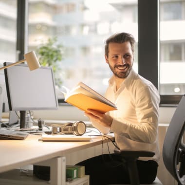 a man sitting by a computer looking to his left