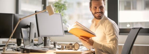 a man sitting by a computer looking to his left