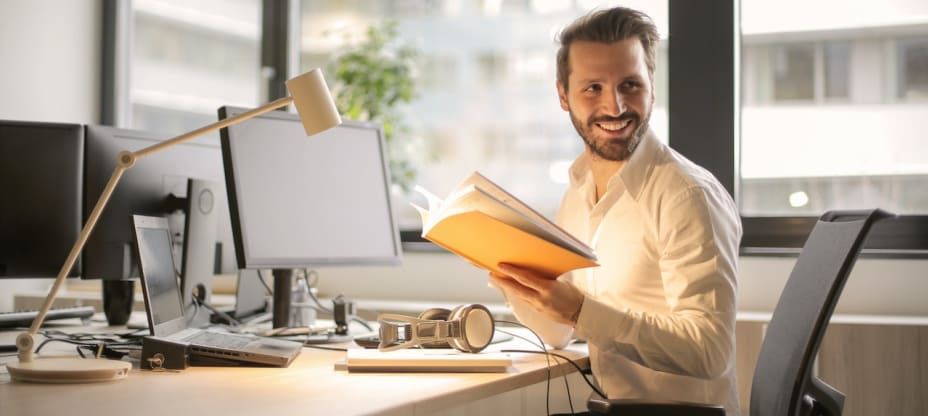 a man sitting by a computer looking to his left