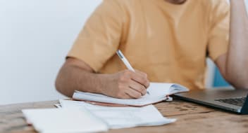 A man sitting at a desk with papers and a computer